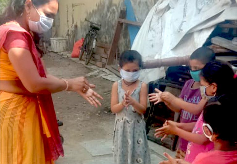 Woman Teaching Children How To Wash Hands